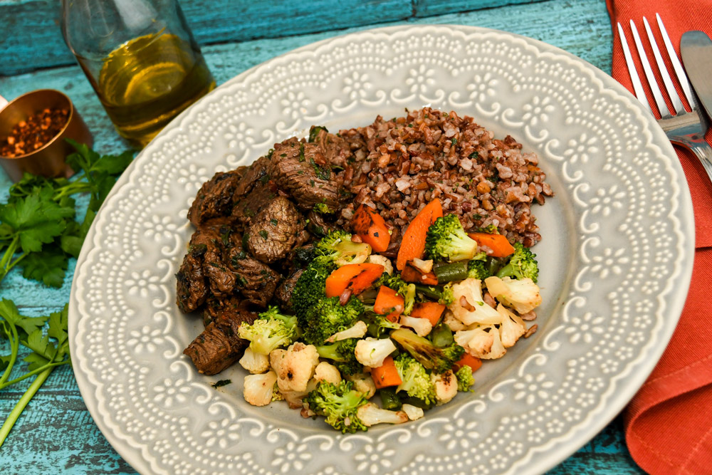 Iscas de filet mignon com cebola tostada, arroz vermelho e jardineira de legumes