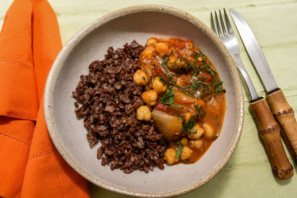 Moqueca de grão de bico, arroz vermelho e legumes cozidos